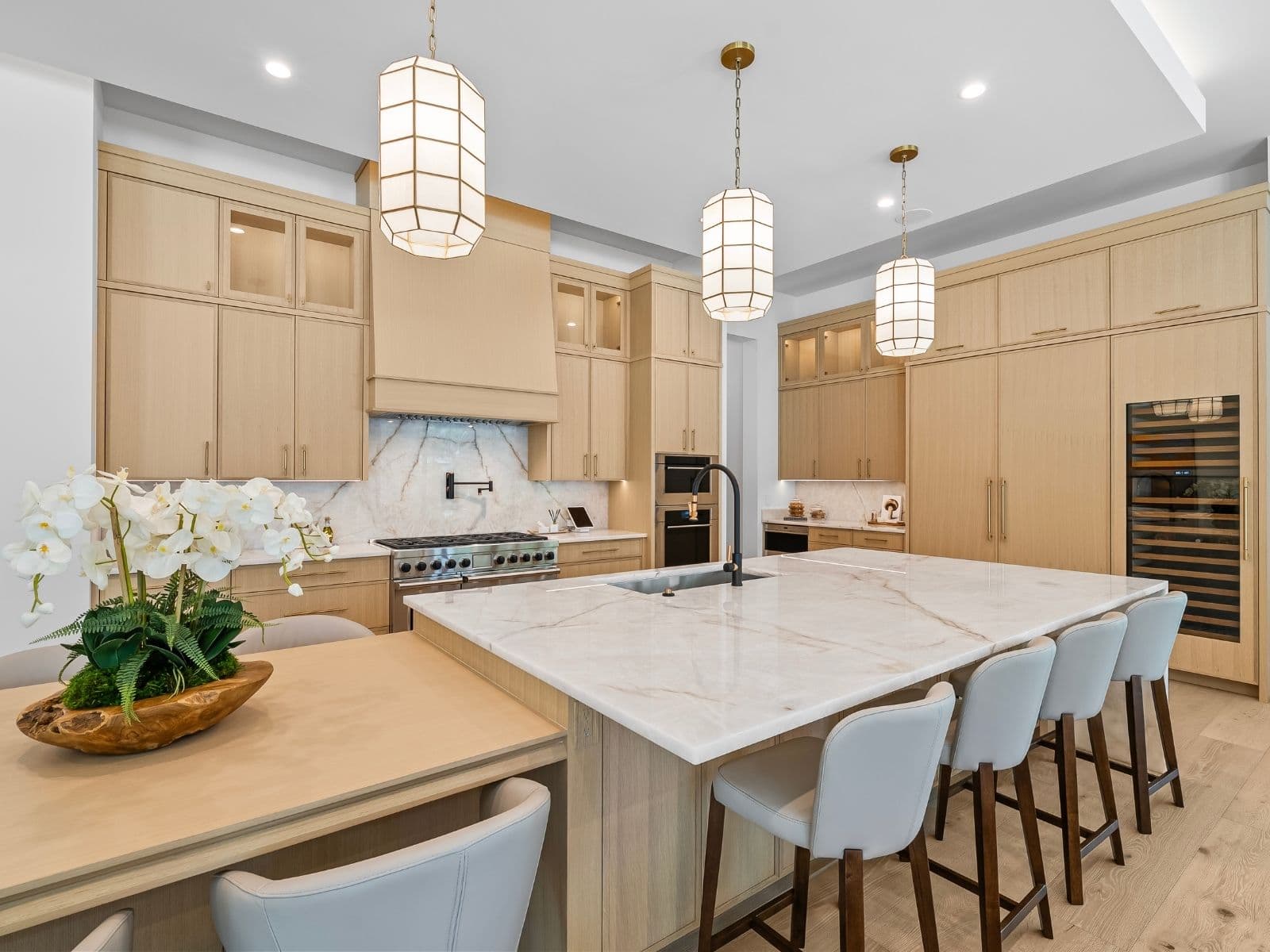 Rift-oak kitchen with a quartzite island and three faceted pendants